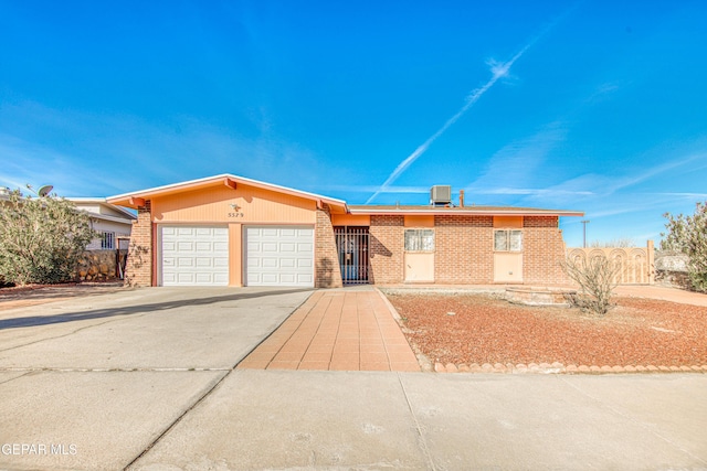 single story home featuring a garage and central air condition unit