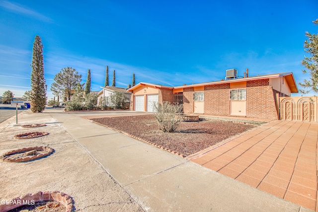 ranch-style home featuring central AC and a garage