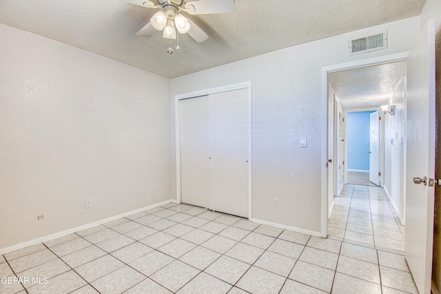 unfurnished bedroom featuring ceiling fan, a closet, and a textured ceiling