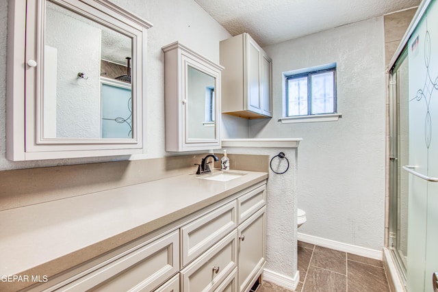 bathroom with tile patterned floors, a textured ceiling, an enclosed shower, toilet, and vanity