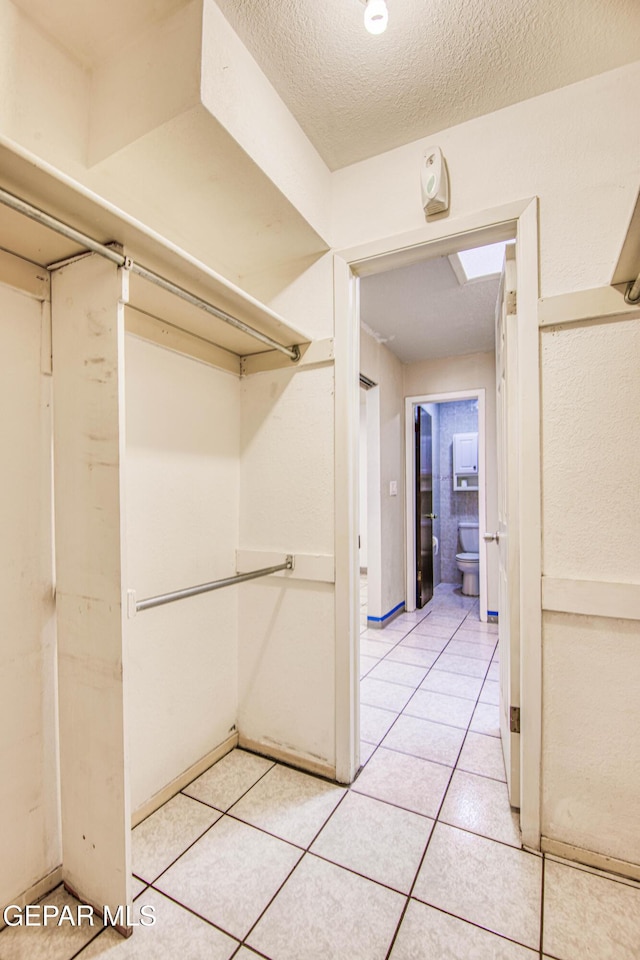 walk in closet featuring light tile patterned flooring