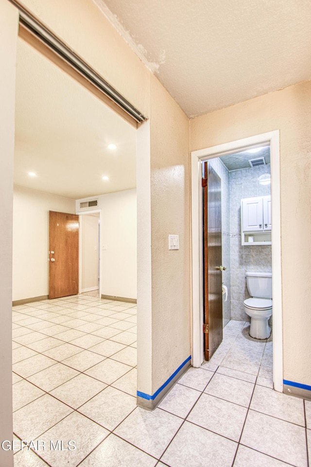 corridor featuring light tile patterned flooring