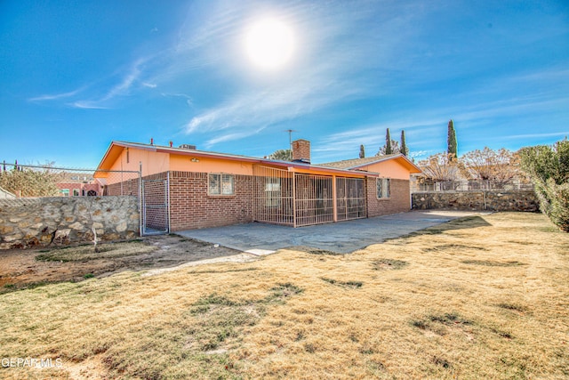 back of house with a lawn and a patio area