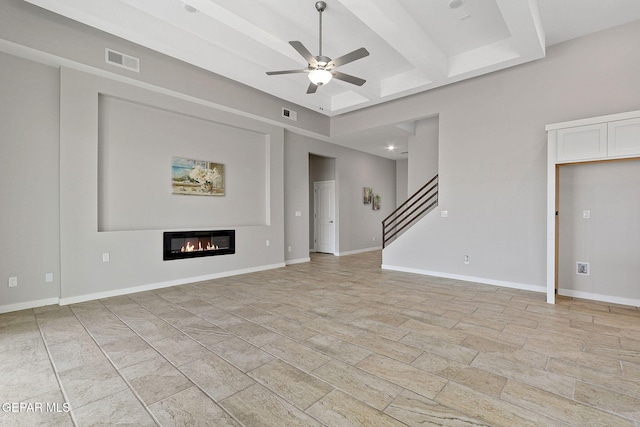 unfurnished living room with ceiling fan and beam ceiling