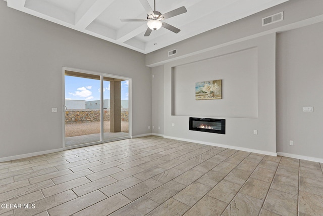 unfurnished living room with ceiling fan, coffered ceiling, and beamed ceiling