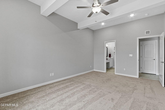 unfurnished bedroom with beam ceiling, ensuite bath, ceiling fan, and light carpet