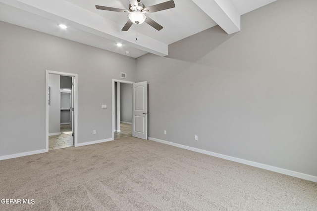 unfurnished bedroom featuring a spacious closet, light carpet, ceiling fan, a high ceiling, and beam ceiling