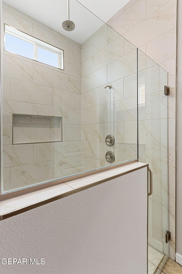 bathroom with a shower with door