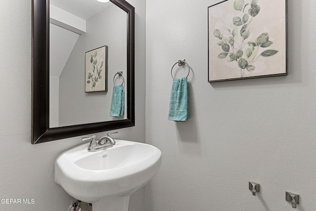 bathroom featuring vaulted ceiling and sink