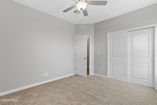 unfurnished bedroom featuring ceiling fan, light colored carpet, and a closet