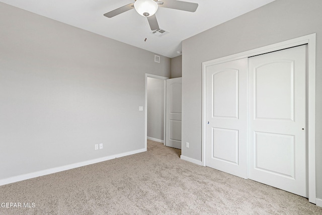 unfurnished bedroom with ceiling fan, a closet, and light colored carpet