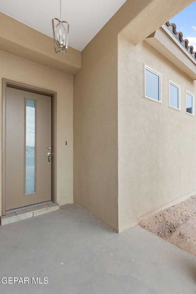 view of exterior entry with a patio area