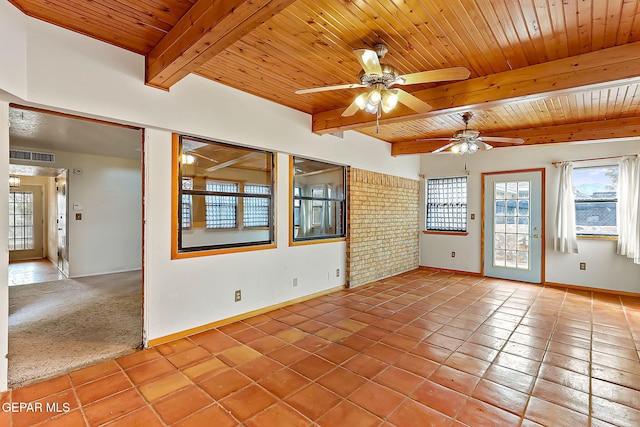 empty room with carpet flooring, beam ceiling, ceiling fan, and wood ceiling