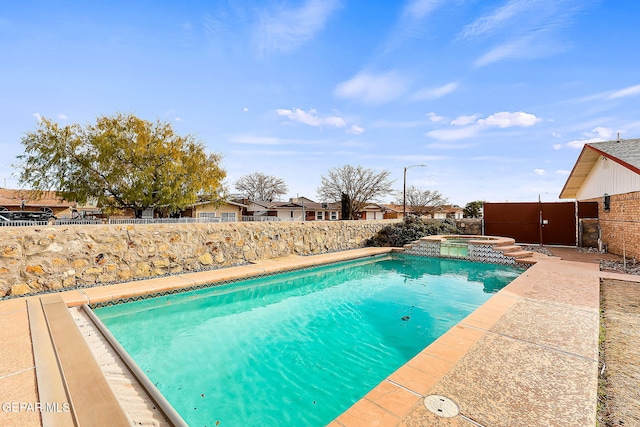 view of swimming pool with an in ground hot tub