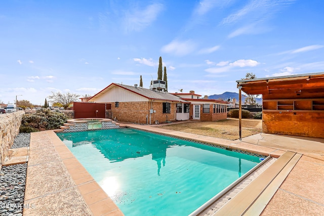 view of pool with an in ground hot tub and a patio