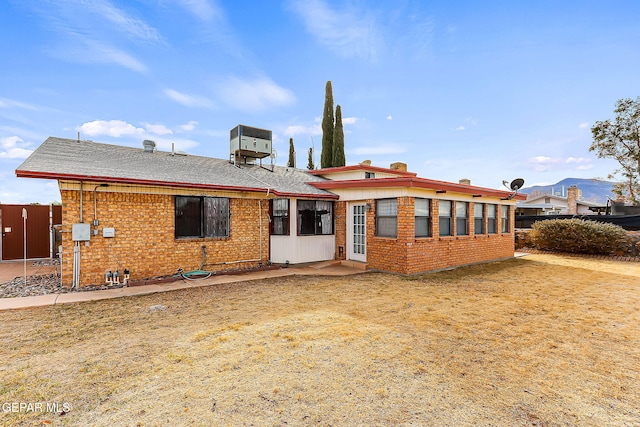 rear view of property with central AC