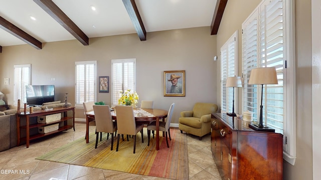 dining space with beamed ceiling