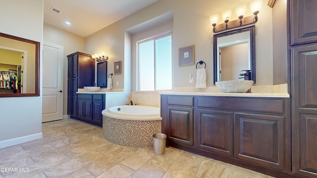 bathroom with vanity and a relaxing tiled tub