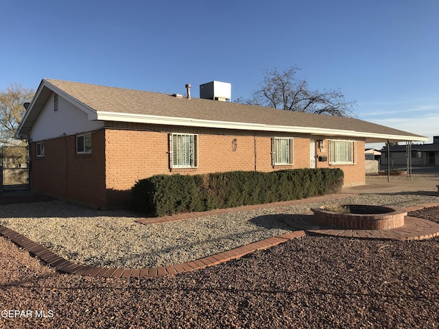 view of home's exterior with a fire pit and a carport