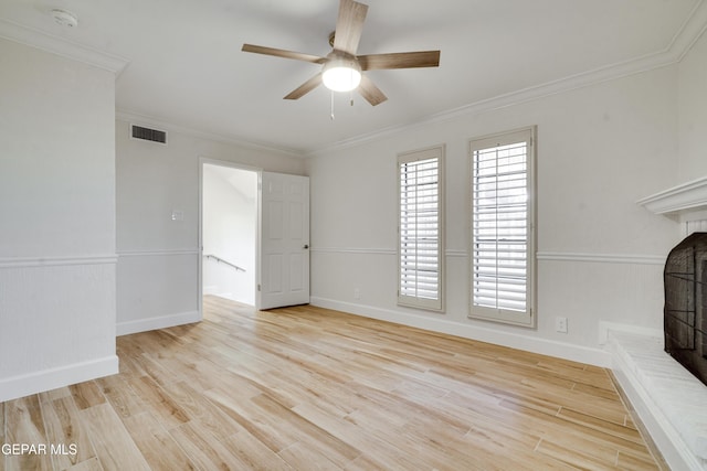 unfurnished living room featuring light hardwood / wood-style flooring, a brick fireplace, ceiling fan, and ornamental molding