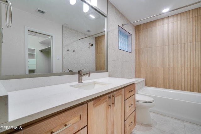 full bathroom with vanity, tile patterned floors, washtub / shower combination, toilet, and tile walls