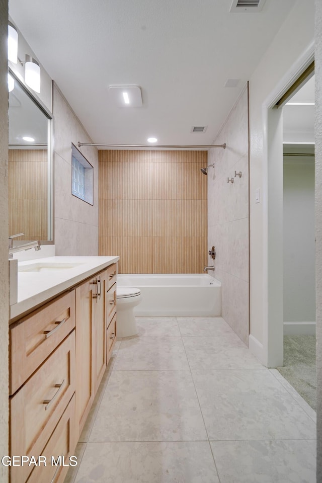 full bathroom with vanity, bathtub / shower combination, tile patterned floors, toilet, and tile walls