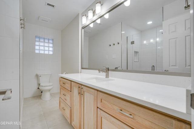 bathroom with tile patterned floors, walk in shower, vanity, and toilet