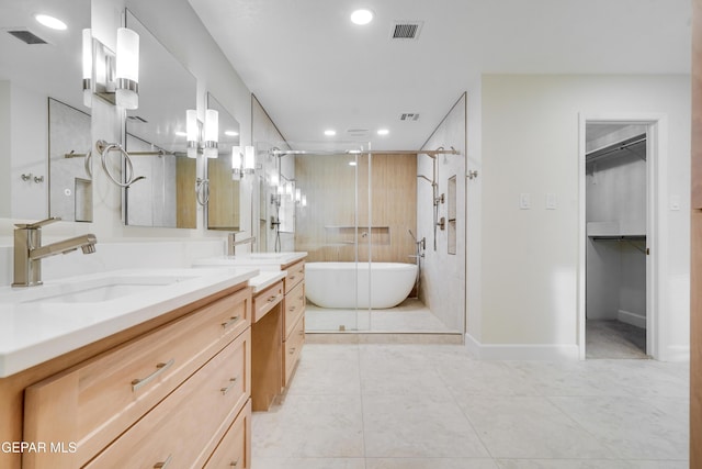 bathroom featuring plus walk in shower, vanity, and tile patterned flooring