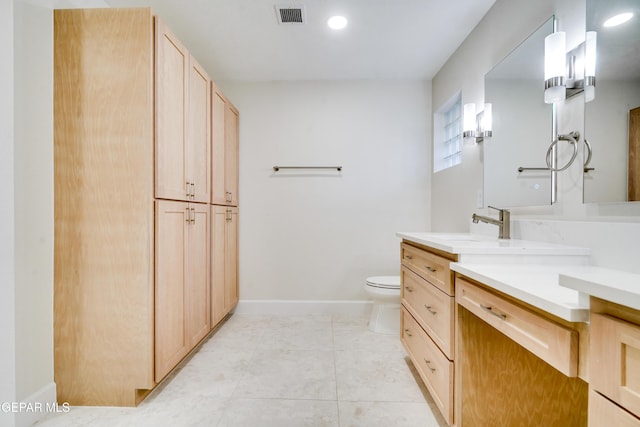 bathroom with tile patterned flooring, vanity, and toilet