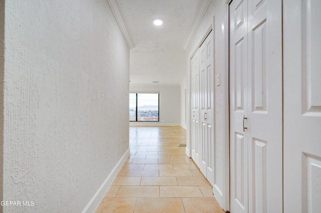 hall with light tile patterned floors and crown molding