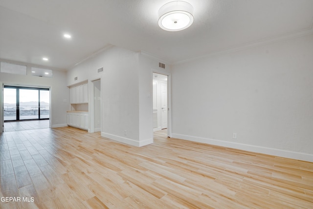 unfurnished living room featuring light hardwood / wood-style flooring and ornamental molding