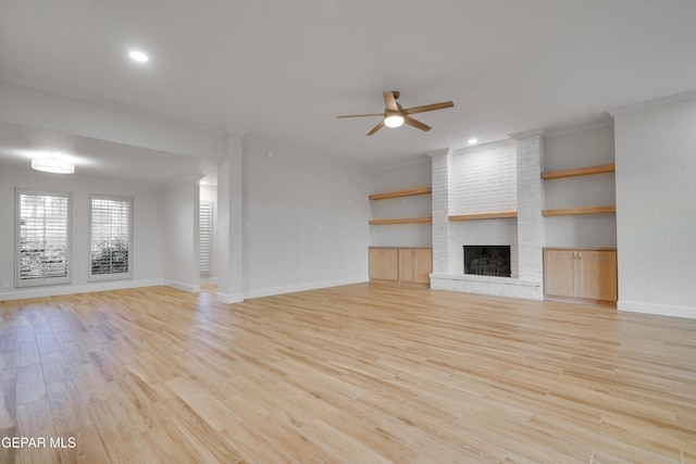 unfurnished living room featuring ornamental molding, built in shelves, ceiling fan, light hardwood / wood-style flooring, and a fireplace