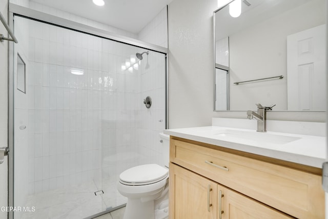 bathroom featuring vanity, toilet, and an enclosed shower