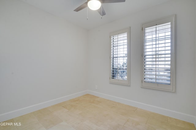 tiled empty room featuring ceiling fan