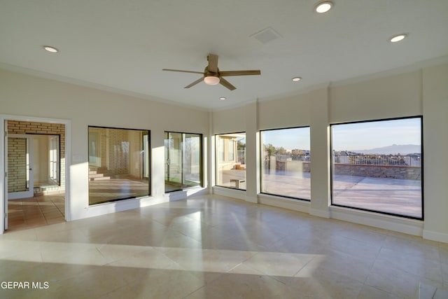 unfurnished room with ceiling fan, ornamental molding, and light tile patterned floors