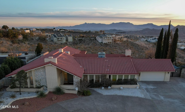 aerial view at dusk featuring a mountain view