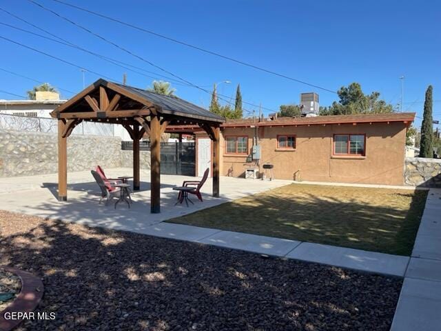 exterior space with a gazebo, cooling unit, and a patio area