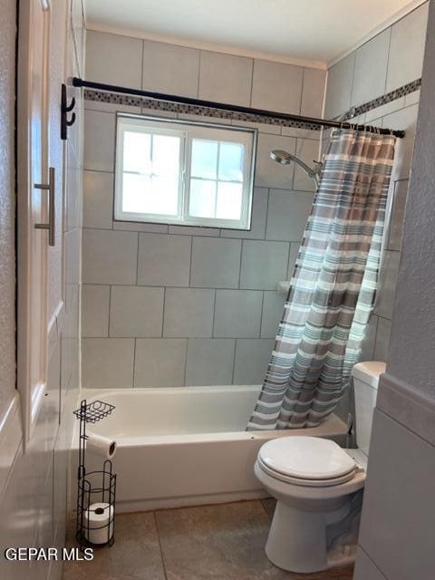 bathroom featuring toilet, shower / tub combo, and tile patterned floors