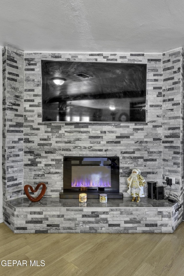 interior details featuring a fireplace, hardwood / wood-style floors, and a textured ceiling