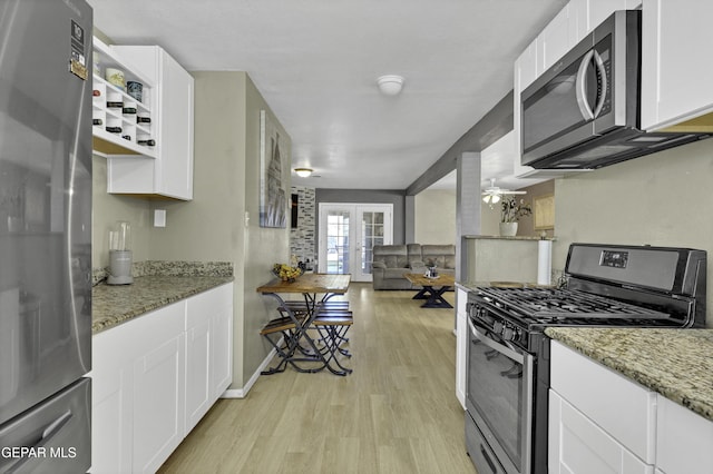 kitchen with dark stone countertops, white cabinets, and appliances with stainless steel finishes