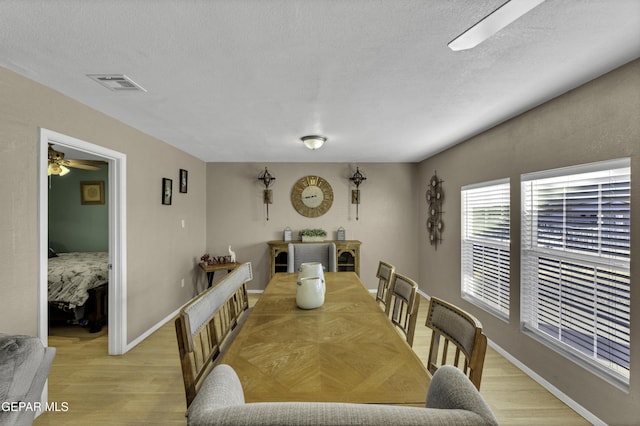 dining area featuring a textured ceiling, light hardwood / wood-style floors, and ceiling fan