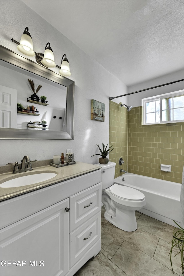 full bathroom featuring a textured ceiling, vanity, toilet, and tiled shower / bath