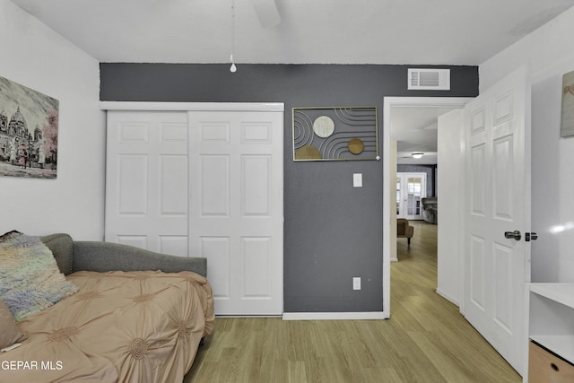 bedroom featuring ceiling fan, a closet, and light hardwood / wood-style flooring