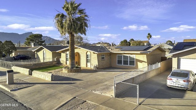 ranch-style home with a mountain view and solar panels