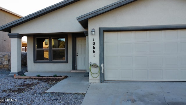 doorway to property with a porch and a garage