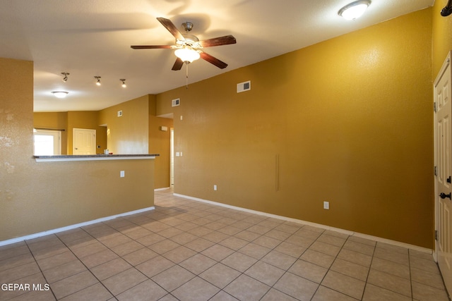 tiled spare room featuring ceiling fan