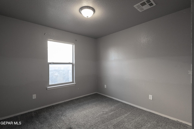 unfurnished room with a textured ceiling and carpet floors