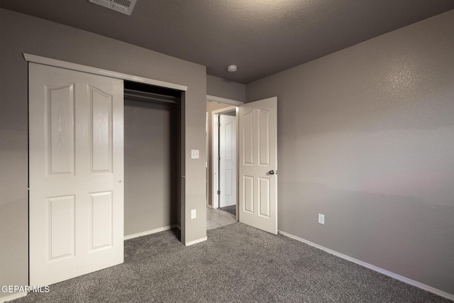 unfurnished bedroom with a closet, carpet floors, and a textured ceiling