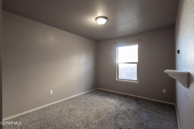 carpeted empty room with a textured ceiling