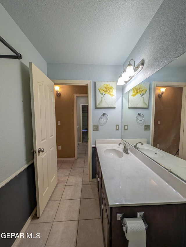 bathroom with tile patterned floors, vanity, and a textured ceiling